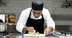 Culinary, plating or man in restaurant with dish, catering or presentation in luxury cuisine. Hospitality, skill or chef in kitchen with meal, dinner preparation or food decorating in fine dining