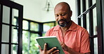 Remote work, reading or black man with tablet in home, proofreading or review article for online publication. Freelancer, research or mature editor with tech to fact check story, grammar or accuracy