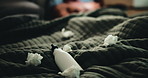 Lotion, tissues and person in bed for temptation, self pleasure and masturbation in home. Night, secret and man with arousal for pornography, addiction and sneaky activity in bedroom of apartment