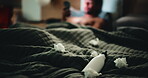 Lotion, tissues and man in bed for temptation, self pleasure and masturbation in home. Night, secret and person with smartphone for pornography, addiction and sneaky activity in bedroom of apartment
