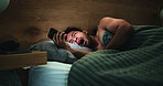 Late, tired man and yawn in bedroom with phone for social media, entertainment or online fatigue. Night, exhausted person and scroll in apartment with tech for mobile app, text message and sleepless.