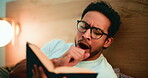 Night, tired man and yawn in bed with book for reading hobby, literature and getting ready to sleep. Late, person and exhausted with glasses in apartment for fiction story, novel and bedtime routine.