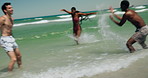 Travel, waves and friends at ocean with fun, bonding and vacation freedom on tropical island. Tourism, beach splash and people in water with adventure, playful energy and summer connection in Cancun.