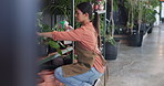 Gardening, watering and woman with plants in nursery for growth, sustainability or healthy leaves. Florist, gardener and person with spray bottle for planting, maintenance or ecology in agro business