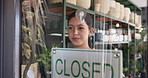 Woman, closed sign and florist at store, window and sustainability with board at small business. Person, botanist and smile at startup, front door or notice with signage at eco friendly flower shop