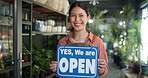 Florist, face of woman and open sign at front door for public notice, start day and friendly welcome. Storefront, employee and happy with signage at plant shop for sustainable startup or announcement