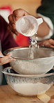 Christmas, helping hand or kid in kitchen with flour, baking support or bonding in holiday season. Festive, parent or child in house with learning, connection or dessert prep in cooking tradition.