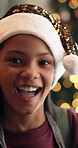 Happy girl, face or home with christmas hat for festive celebration, december holiday or new year. Portrait, child or kid with smile or sparkle on bokeh for party, festivity or santa weekend in house