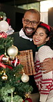 Happy couple, christmas and home with tree decor for festive spirit or celebration together. Man, woman or smile with decoration box, hug or bauble for december holiday or santa tradition in house