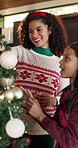 Happy mom, child and christmas tree with bauble for festive decoration or celebration together. Mother, kid or daughter with smile, bonding or decor for december holiday or santa tradition in home