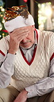 Sad, Christmas and thinking with old man on sofa for reflection, festive crisis and mistake. Gift giving pressure, worry and holiday stress with senior person in living room of home for memory