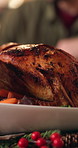 Christmas, dinner and roast chicken in home with vegetables for traditional meal, feast and cuisine. Person, meat dish and food in house for festive holiday, social gathering and healthy nutrition.