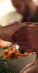 Holding hands, Christmas and gratitude with family at dining room for prayer, festive season and love. Spiritual, celebration and dinner with people in home for faith, xmas holiday and support