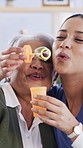 Bubbles, laugh and nurse with senior woman in retirement home for checkup with bonding together. Happy, soap toy and caregiver with elderly female patient for medical support, connection or game.