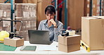 Laptop, logistics and thinking with woman at desk in warehouse for distribution or shipping update. Computer, supply chain and typing with mature person in storage depot for agenda or schedule