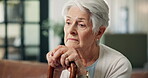 Sad, old woman and thinking with walking stick on sofa for grief, memory and lonely in retirement. Unhappy, cane and senior person with depression in home for partner loss, regret and mental health