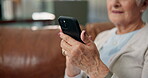 Typing, phone and hands with old woman on sofa for social media, ebook subscription and app. Online library, retirement and calm with senior person and tech in living room of home for weekend break