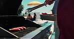Barbecue, hotdog and grill with hands of person outdoor for cooking, celebration and lunch. Nutrition, bbq hangout and health with people and cookout event on patio of home for food and meat