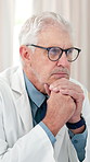 Thinking, doctor and mature man in office to review patient report, treatment plan and wellness. Healthcare, clinic and person with glasses for medical research, decision and reading for diagnosis