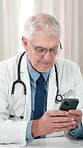 Doctor, healthcare or man in hospital with phone, update surgery schedule or feedback. Mature surgeon, mobile or typing in office for telehealth consultation, medical forum discussion or calendar app