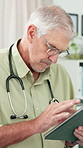 Mature, doctor and man with tablet for healthcare research, scroll or check patient history. Person, technology and medical professional in hospital for wellness email, records and reading report