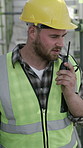Contractor, man and talk on construction site with radio, building instructions and engineer feedback. Builder, person outdoor and speaking with tech, risk assessment or quality assurance inspection.