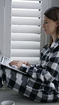 Woman, laptop and relax on floor in bedroom, smile and typing with search for movie on break at home. Girl, computer and pyjamas on carpet with streaming service, subscription or film choice in house