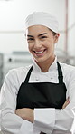 Face, woman and chef with arms crossed in restaurant kitchen for career pride as culinary expert. Portrait, female person and professional cook with smile, food preparation and ambition for catering