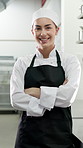 Face, woman and cooking with arms crossed in restaurant kitchen for career pride as culinary expert. Portrait, female chef and smile for quality assurance, food preparation and ambition for catering