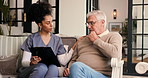 Couch, caregiver and old man with clipboard for conversation, review medical results or empathy. Health discussion, elderly care support or nurse with senior person in home, comfort or diagnosis info