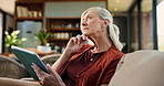 Tablet, thinking and senior woman on sofa in home with reading comedy blog on app for entertainment. Relax, digital technology and elderly female person on social media in living room at house.