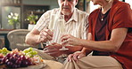 Senior couple, cheers and champagne glasses with fruit in home for anniversary celebration or date. Hands, elderly man and woman with alcohol or toast for valentines day, bonding or romance in house