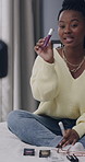 Influencer, talking and black woman with makeup in home for application, how to and tutorial. Content creator, bedroom and person with cosmetics for product review, beauty tips and social media