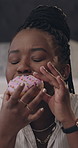 Black woman, influencer and bite donut in home, sweet snack and review junk food on web show. African person, face or eating dessert with opinion for live streaming, cake or social media at apartment