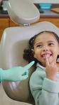 Dentist, child and smile in consultation with inspection, oral hygiene or healthcare for wellness. Dental hygienist, girl or kid in office for mouth examination, medical assistance or point at teeth.