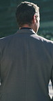 Back, business and man walking in city for travel, real estate agent and urban development. Male person, realtor and morning commute for venture, property search and commercial trip of infrastructure