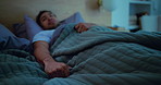 Nightmare, scared and man in bed at night with fatigue, insomnia and anxiety for bad dreams in home. Dark, awake and hands of afraid person with blanket for sleep issue, fright and fear in bedroom