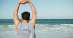 Back, beach and man with fitness, stretching and wellness with waves, morning routine and workout. Ocean, training and healthy person with breathing exercise, coastline and warm up with balance