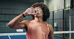 Padel, man or drinking water on court with bottle, tournament break or contest pause for hydration. Thirsty, tennis player or person at sports club with liquid, beverage or electrolytes for recovery.