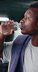 Black man, fitness and drinking with water in gym for hydration, workout break or recovery. Active, thirsty or male person with mineral liquid, bottle or beverage for exercise or rest in health club