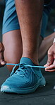 Fitness, shoes and hands with lace in gym, workout preparation and indoor sports training for wellness. Getting ready, athlete or person tie sneakers in health club, morning routine or start exercise
