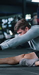 Fitness, getting ready and stretching with man on gym floor for start of training or workout routine. Breathing, exercise and leg warm up with person in health club for challenge or preparation