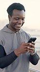 Phone, fitness and black man by beach for running with texting, social media or contact online. Technology, outdoor and African athlete with cellphone for chatting on mobile app with cardio workout.