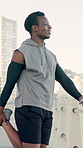 Stretching, fitness and black man on promenade for running, workout or wellness training. Happy, boardwalk and African male athlete with warm up leg exercise for cardio by ocean on morning for health