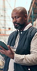 Black man, reading and tablet for logistics in warehouse for stock, inventory and supply chain. Mature person, digital and inspection for quality assurance, export records and information of shipping