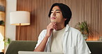 Laptop, planning and remote work with Asian man on sofa in home living room for ideas or research. Computer, development and thinking with freelance entrepreneur in apartment for startup business