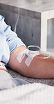 Person, injection and therapy with IV drip for blood infusion, vitamins or immune booster in clinic. Closeup, patient or arm with artery vein, shot or pipe for detox, nutrition or healthcare recovery