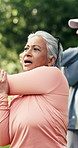 Senior woman, fitness and stretching with group in park for physical activity or outdoor exercise. Elderly, female person or class with body warm up for lesson, health and wellness together in nature