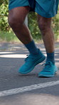 Legs, running and man with fitness, sneakers and challenge for intense training, wellness and exercise. Shoes, runner and person in street, progress and cardio workout for health benefits and balance