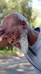 Fitness, sweating and man with tired breathing outdoor for running fatigue, cardio break and recovery. Mature black person, exhausted athlete and exhale in nature for intense workout and overworked